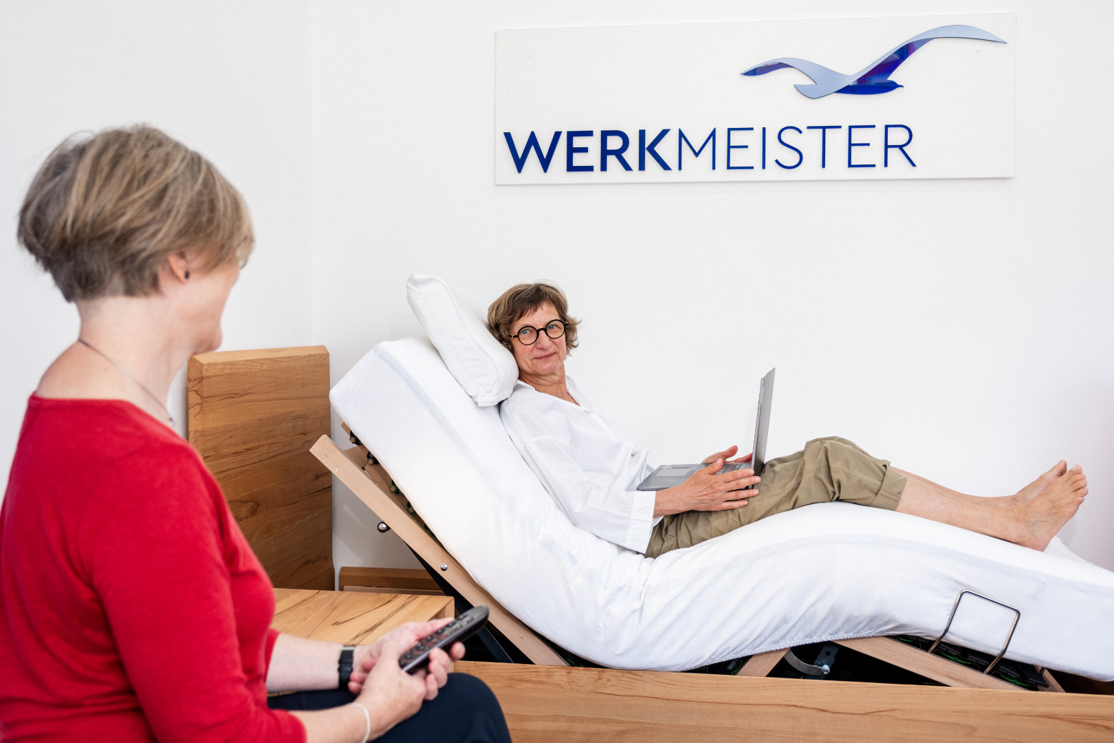 Kundin liegt auf einem elektrisch verstellbaren Werkmeister-Bettsystem bei Betten VIKINGS und erhält eine ergonomische Beratung